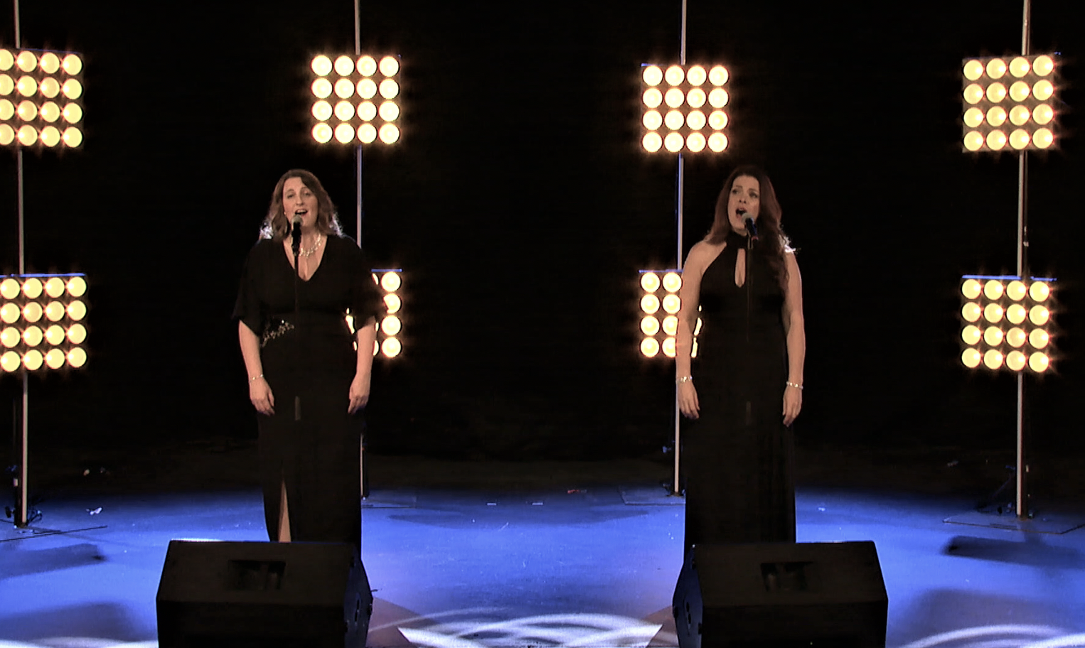 two ladies sing on cruise ship stage